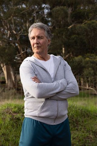 Mature Man in Grey Hoodie Enjoying Nature in Peaceful Field