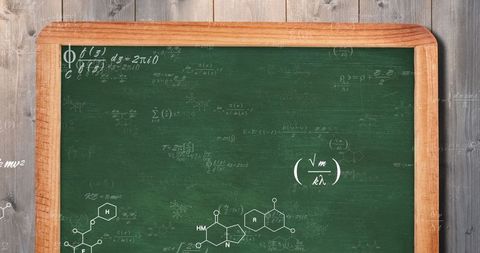 Vintage chalkboard with chemical and physics formulas on wooden wall