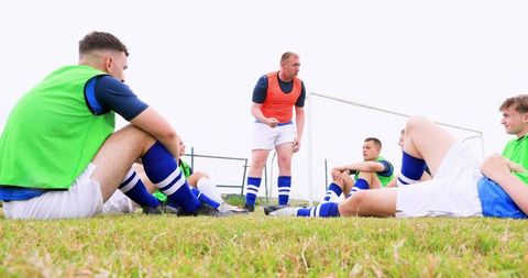 Soccer Coach Giving Team Strategy on Field