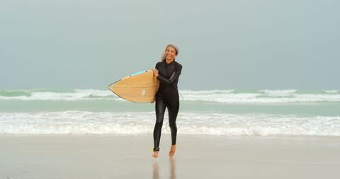 Senior African American Woman Running on Beach with Surfboard - Download Free Stock Images Pikwizard.com