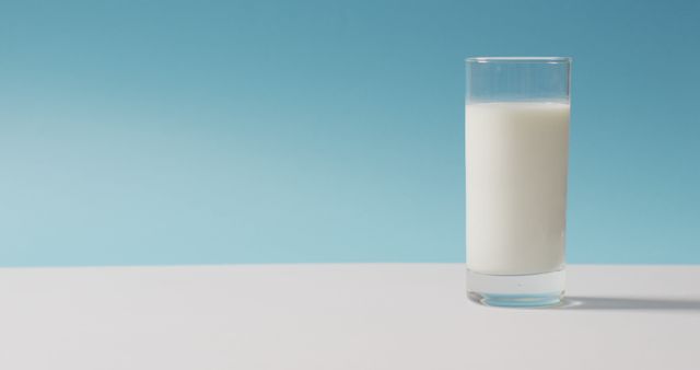 Image of glass of fresh milk over blue background. dairy products and healthy organic nutrition.