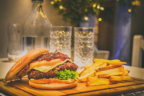 Delicious cheeseburger and fries on wooden board