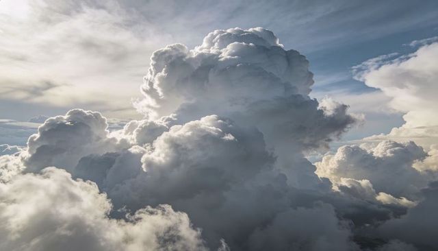 Towering Cumulonimbus Thunderhead Rising over High-Altitude Sky with Backlit Anvil and Sunlit Edges