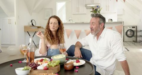 Couple Enjoying Indoor Gourmet Snacking with Wine