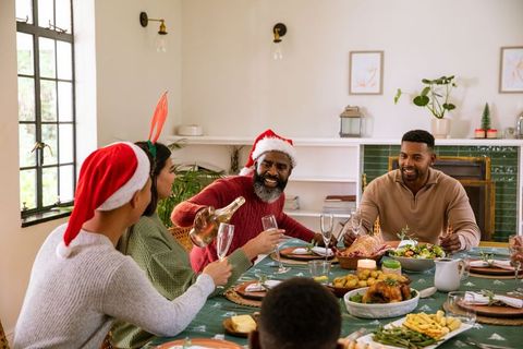Family celebrating holidays with champagne at festive dining table