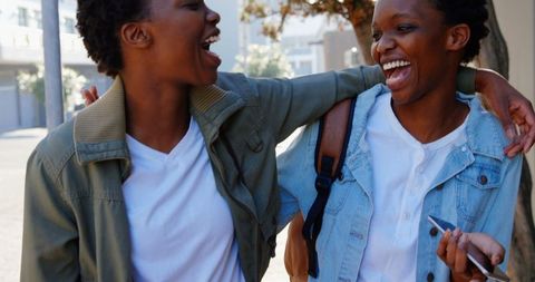 Cheerful African American Twin Sisters Enjoying City Stroll
