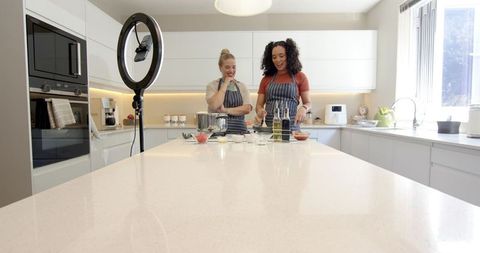 Diverse friends cooking in modern kitchen with ring light