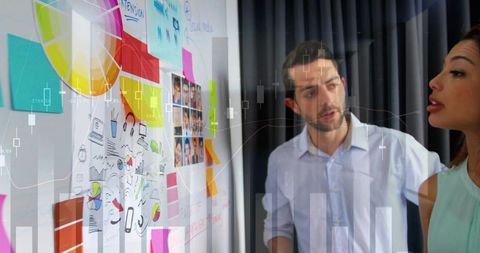Colleagues brainstorming at planning wall with colorful sticky notes, charts and sketches