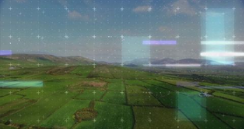 Aerial hud overlay over patchwork farmland spanning rural valley with hedgerows and hills
