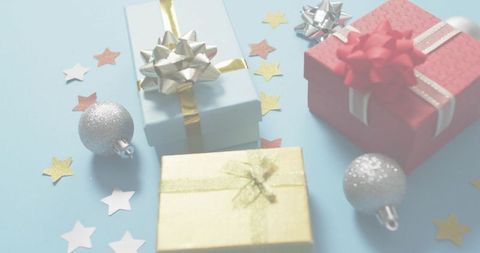 Pastel gift boxes with metallic bows, silver baubles and star confetti for festive use