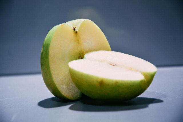 Close-up of Fresh Green Apple Cut in Half on Gray Background - Download Free Stock Photos Pikwizard.com