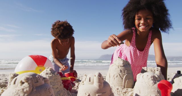 African american brother and sister playing with sand on the beach - Download Free Stock Photos Pikwizard.com