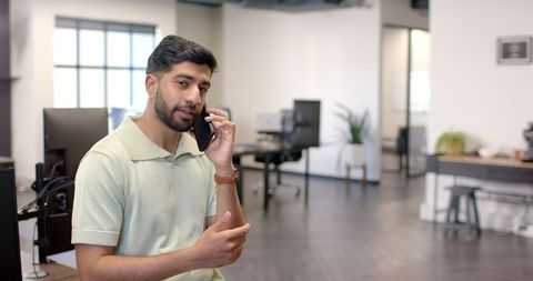 Young Professional Man Talking on Smartphone in Modern Office
