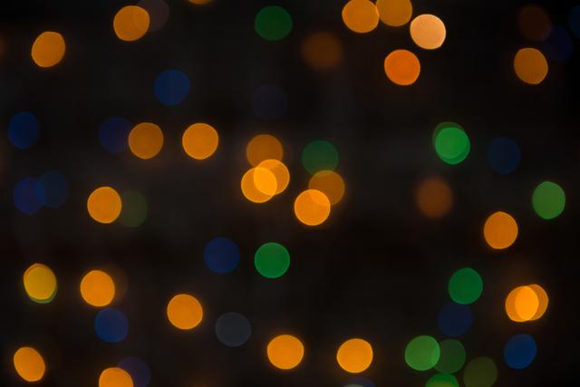 This image of colorful bokeh lights against a dark background is perfect for festive and holiday-themed designs. It can be used in Christmas cards, party invitations, or as a background for websites and social media posts. The vibrant and blurred lights create a warm and celebratory atmosphere.