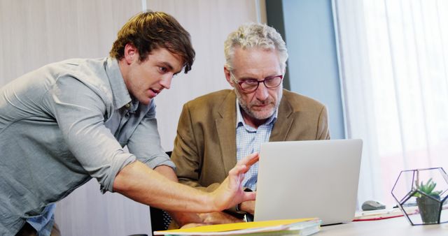 Young professional mentoring senior colleague in office - Download Free Stock Images Pikwizard.com