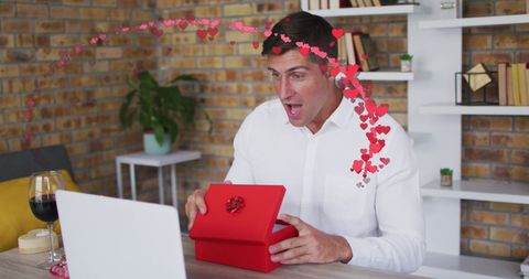 Man Delightedly Discovering Surprise in Red Gift Box Online