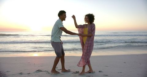 Couple Enjoying Sunset Walk on Sandy Beach