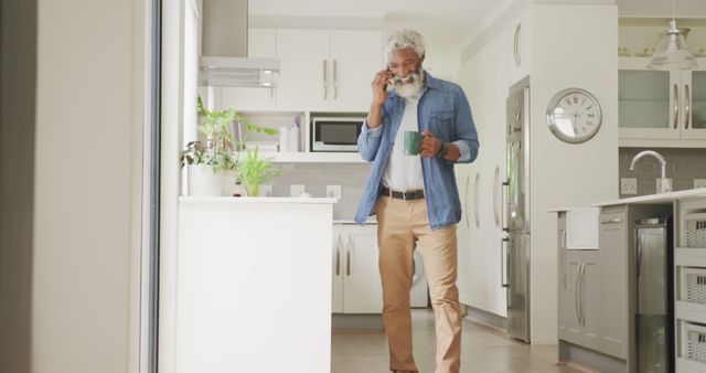 Senior Man Drinking Coffee While Talking on Phone in Modern Kitchen Interior - Download Free Stock Images Pikwizard.com