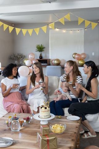 Women celebrating 30th birthday with friends and newborn
