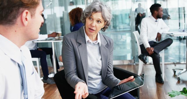 Senior Businesswoman Discussing Strategy with Colleagues in Modern Office - Download Free Stock Images Pikwizard.com