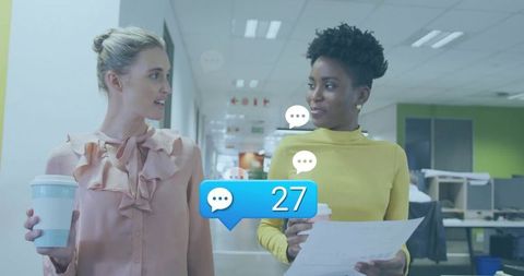 Two Colleagues Chatting Over Coffee in Modern Office