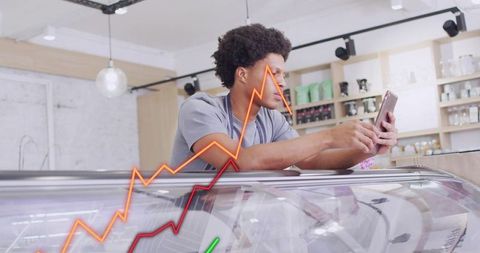 Leaning cafe worker checking smartphone with rising sales graphs and business analytics