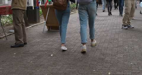Friends Strolling Sidewalk in Jeans on Sunny Day