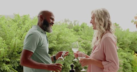 Romantic Couple Enjoying Wine Outdoors in Lush Garden