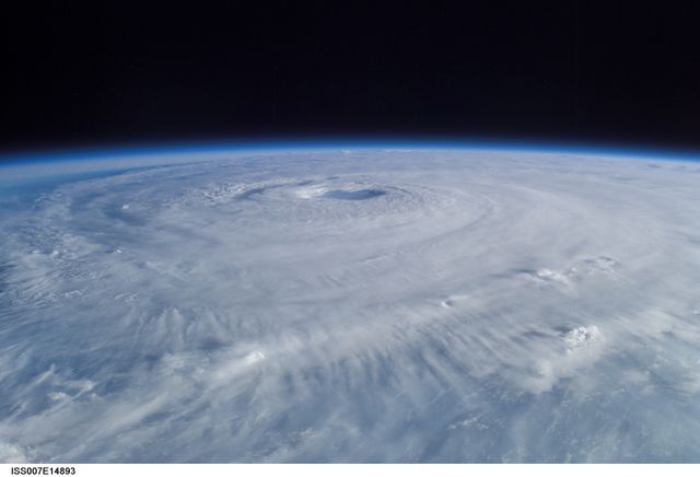 Aerial view of Hurricane Isabel captured from the International Space Station in September 2003. The swirling cloud formations and central eye of the hurricane are distinctly visible. This stock image can be used for educational materials, scientific articles, weather reports, environmental analysis, and discussions on climate change.