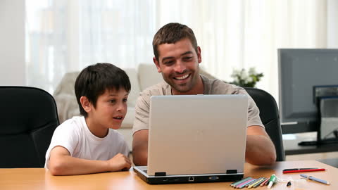 Father and Son Engaging with Laptop Together