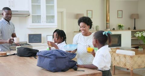 Family morning routine preparing for school with backpacks and juice