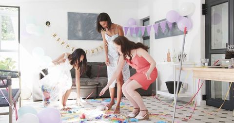 Friends Cleaning After Birthday Party in Bright Living Room