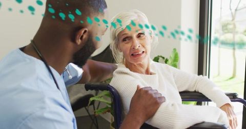 Caregiver Offering Comfort to Senior Woman in Wheelchair by Sunlit Window