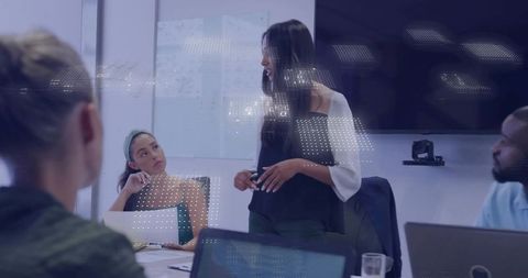 Female leader presenting to diverse team in modern conference room with technology overlay