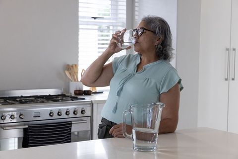 Senior Woman Hydrating in Modern Home Kitchen