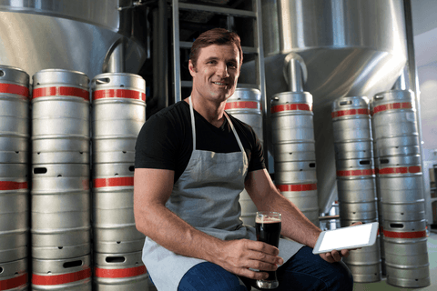 portrait of brewmaster holding tablet in craft brewery with beer kegs - Download Free Stock Videos Pikwizard.com