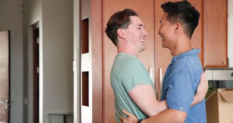 Joyful LGBT Couple Dancing Together at Home in Kitchen