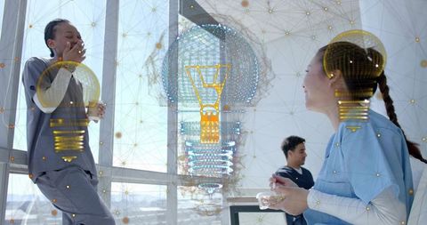 Medical team collaborating with augmented reality holograms in sunlit modern hospital