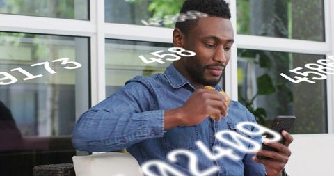 Man eating sandwich while using smartphone in lounge with floating numeric overlay