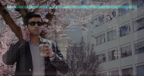 Urban professional talking on phone holding coffee under cherry blossoms with code overlay