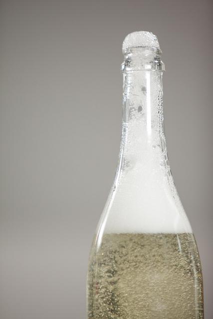 Close-up of champagne bottle with froth overflowing, perfect for illustrating celebrations, parties, and festive occasions. Ideal for use in advertisements, social media posts, and event invitations.