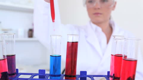 Female Scientist Experimenting with Colorful Liquids in Lab