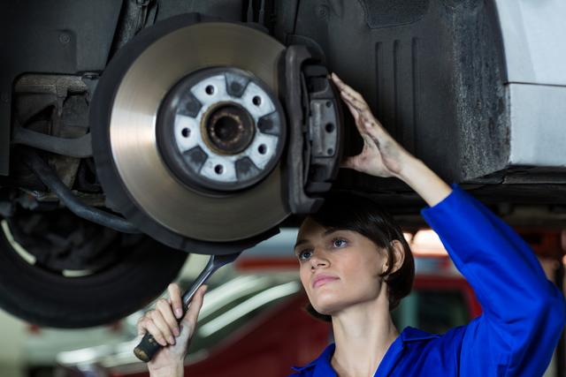 Female Mechanic Repairing Car Disc Brake in Garage - Download Free Stock Images Pikwizard.com