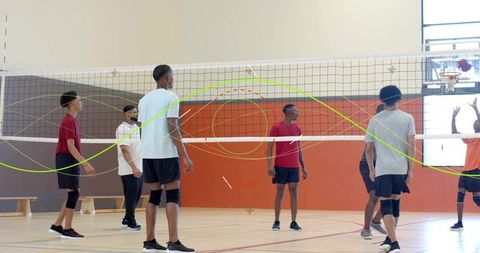 High school volleyball players tracking ball at net with motion arc overlay showing rally
