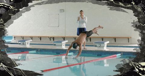Competitive swimmer diving into indoor lane while coach timing with stopwatch start drill
