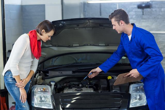 Mechanic showing customer the problem with car - Download Free Stock Photos Pikwizard.com