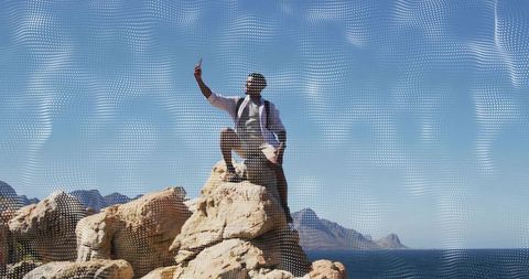 Hiker Capturing Selfie on Rocky Coastal Outcrop While Backpacking Along Ocean Horizon