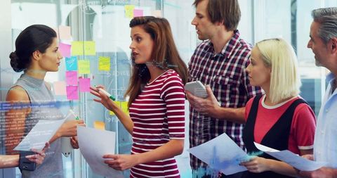 Diverse Team Planning with Sticky Notes and Technology in Modern Office