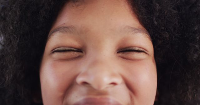 Close-Up of Smiling Child with Curly Hair and Eyes Closed - Download Free Stock Images Pikwizard.com