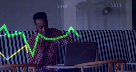 Working man analyzing financial charts on laptop in cafe coworking lounge